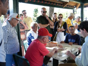 Thomas tries his hand at dominoes (after saying, "How do you play dominoes?") with a group of folks in Little Havana at the Maximo Gomez Park. Maximo Gomez was the military leader in the 1895 War of Independence from Spain.