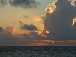 The sun rises behind clouds on our last day at South Water Caye. 