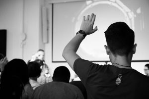 Person raising their hand in a group